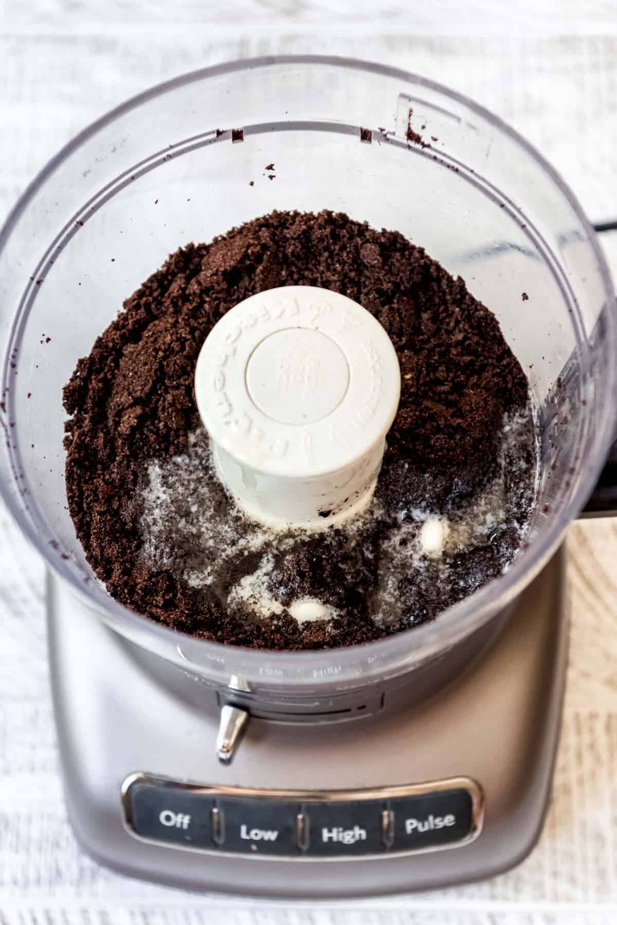 Oreo cookies have been blended in a food processor, preparing to make a crumb crust. 