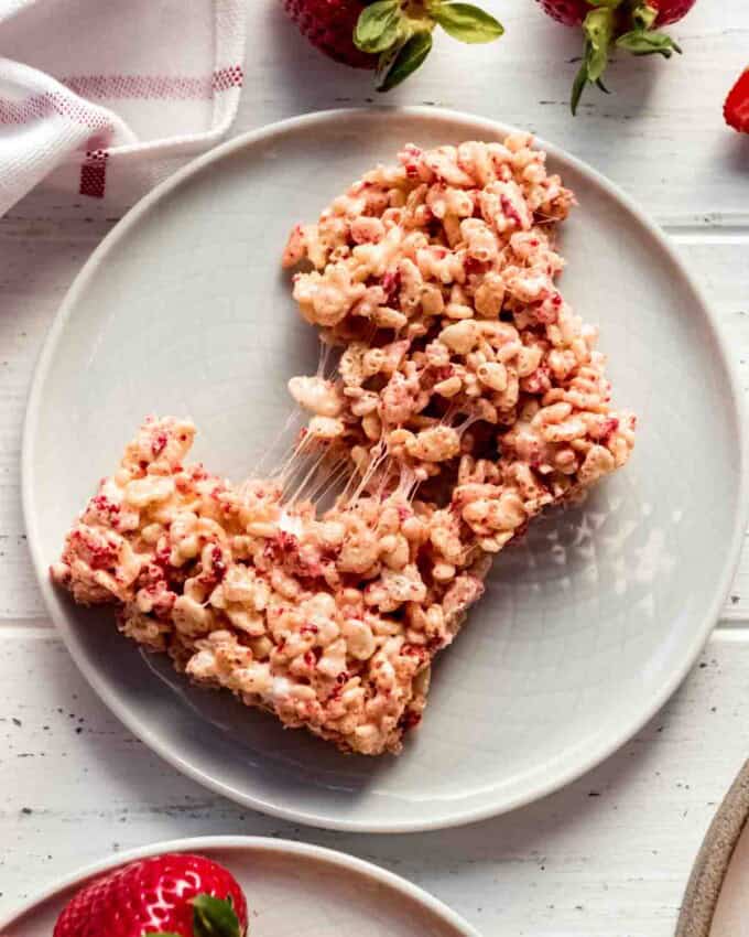 Strawberry Rice Krispies Treat pulled apart on a white plate.