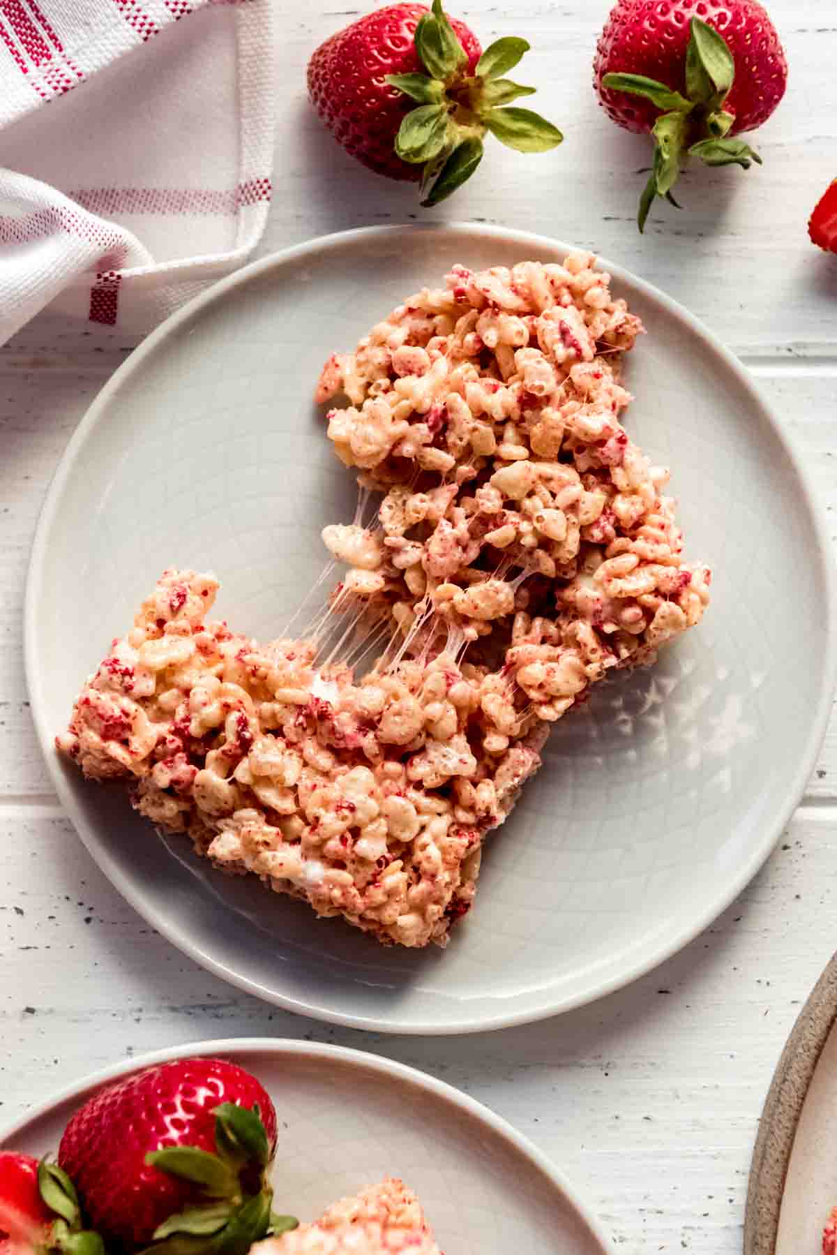 Strawberry Rice Krispies Treat pulled apart on a white plate.