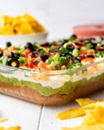 7 layer dip in a 9x13 glass dish with a side of chips.