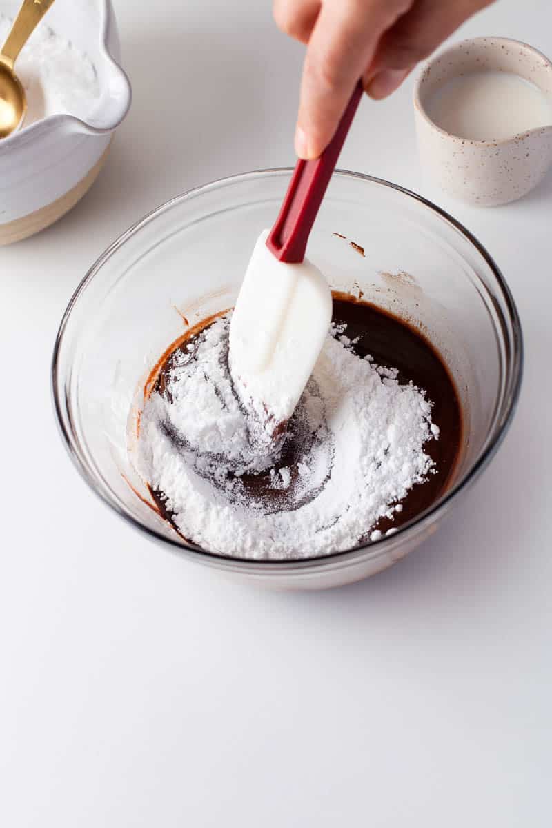 Powdered sugar is stirred into a chocolate mixture. 