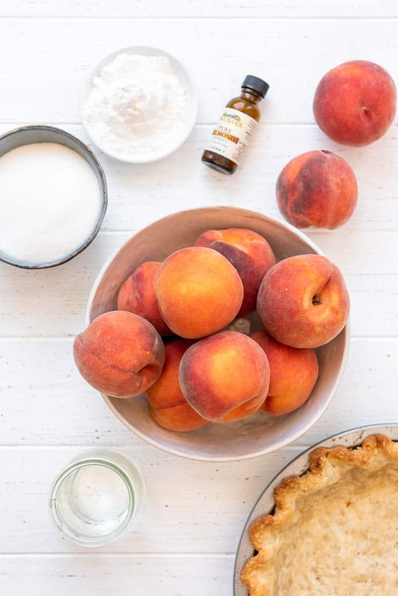 ingredients for fresh peach pie include peaches, sugar, cornstarch, almond extract, water, and a pie crust