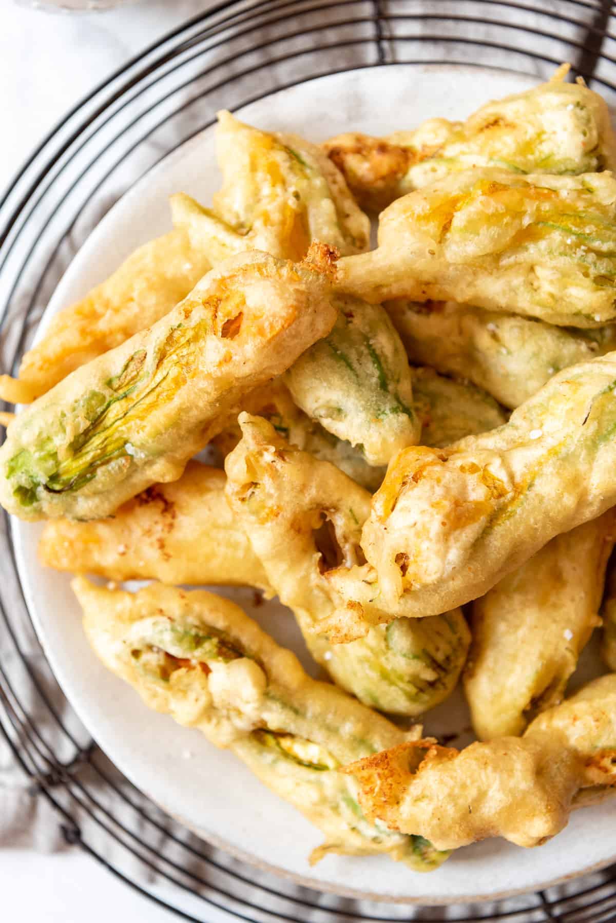 An close up overhead image of fried squash blossoms on a plate.