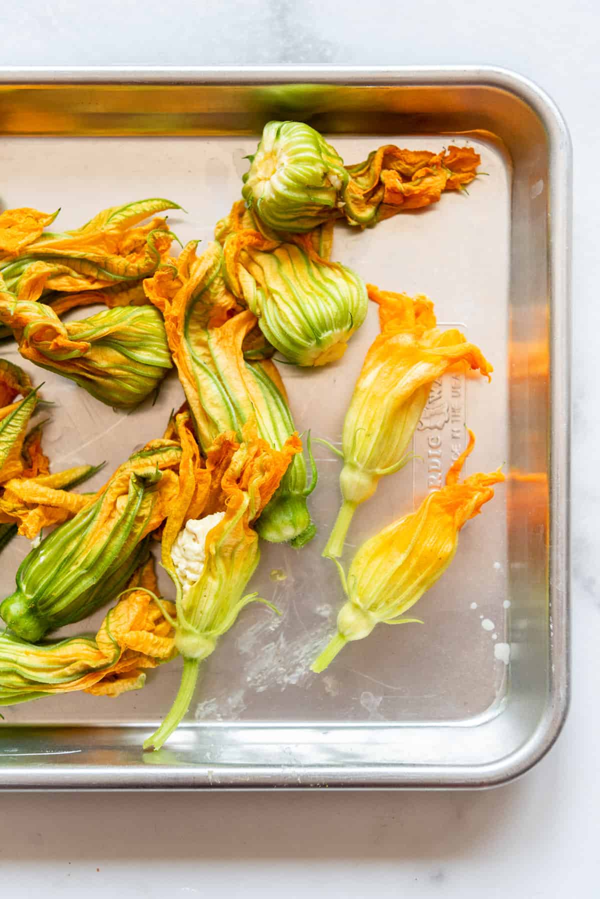 An close up overhead image of fried squash blossoms on a plate.