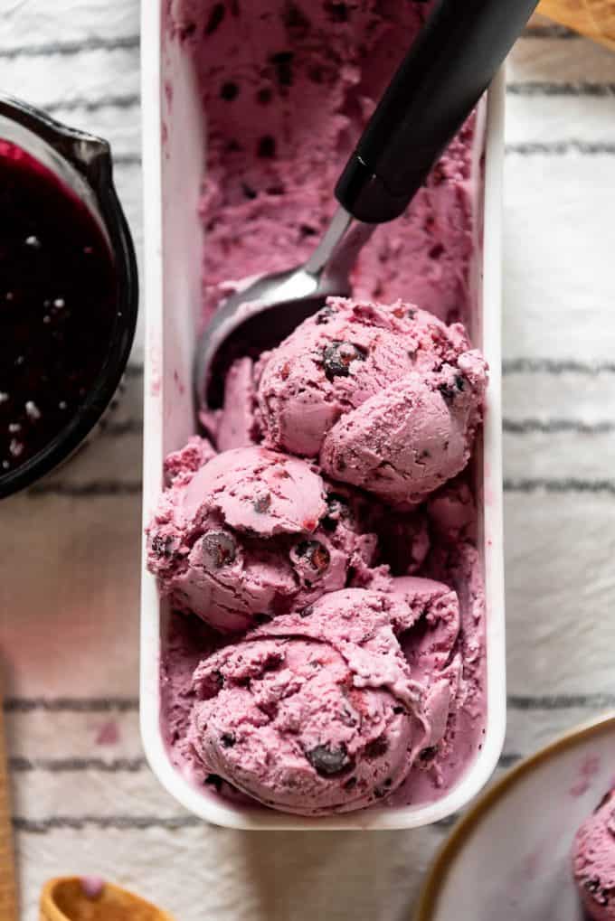 scoops of huckleberry ice cream in a white container