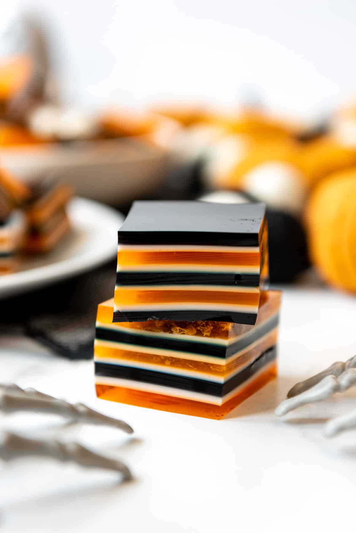 Striped squares of jello in orange, black, and white for a Halloween finger food.