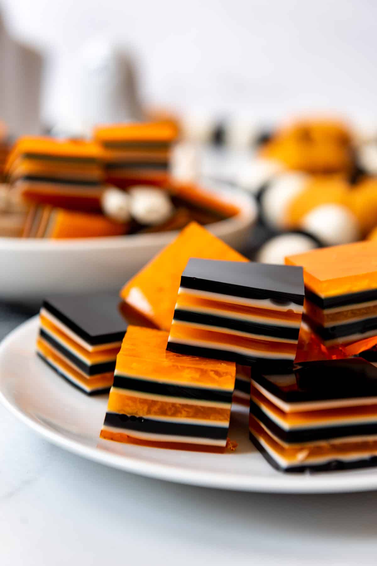 Layered Halloween jello squares on a white plate.