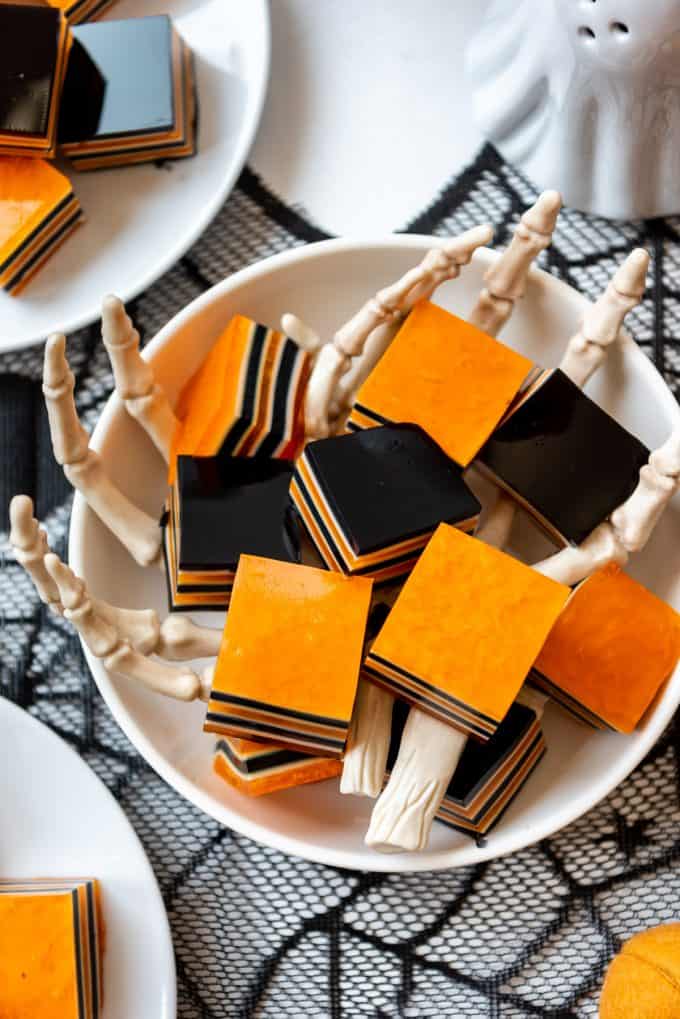 Orange and black squares of Halloween jello jigglers in cube shapes.
