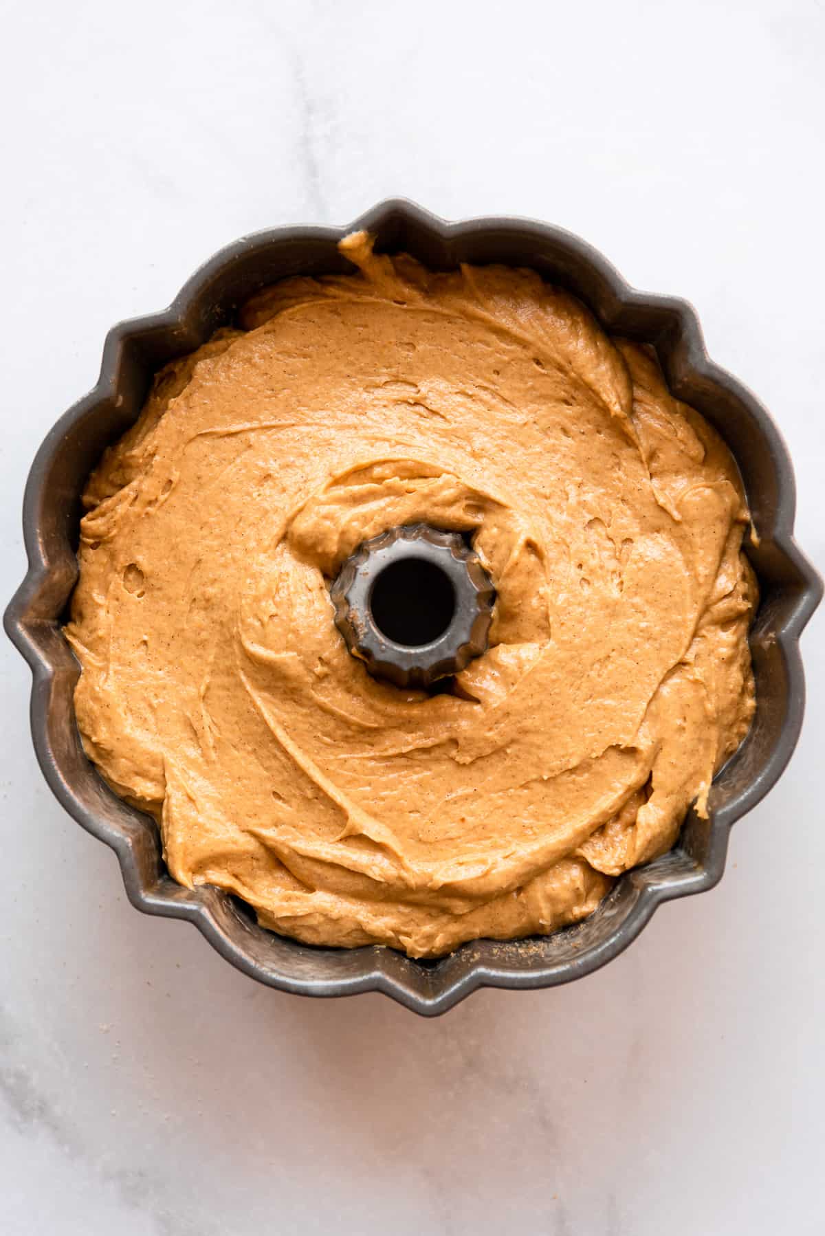 Pumpkin cake batter tops the brown sugar mixture in the bundt pan. 