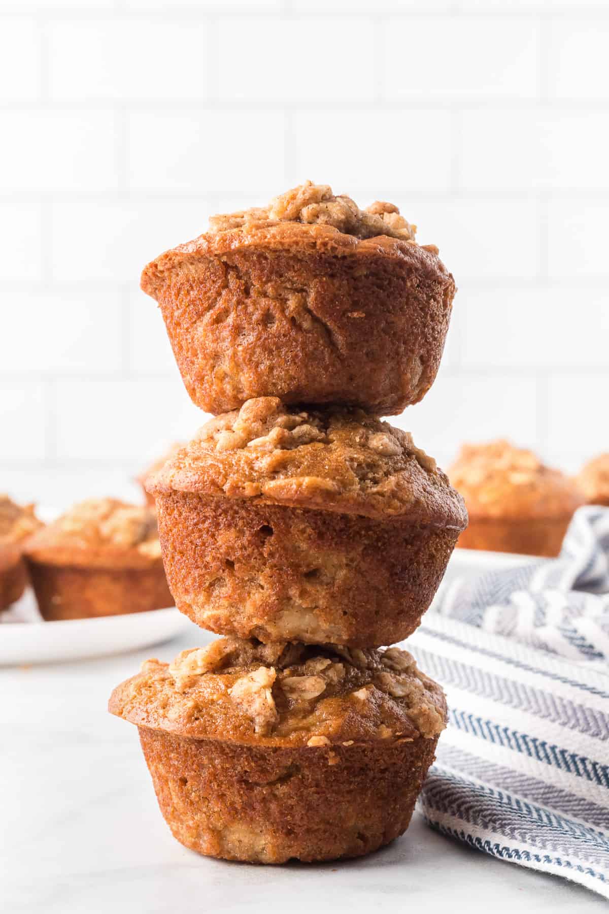 three apple oatmeal muffins stacked in a tower.