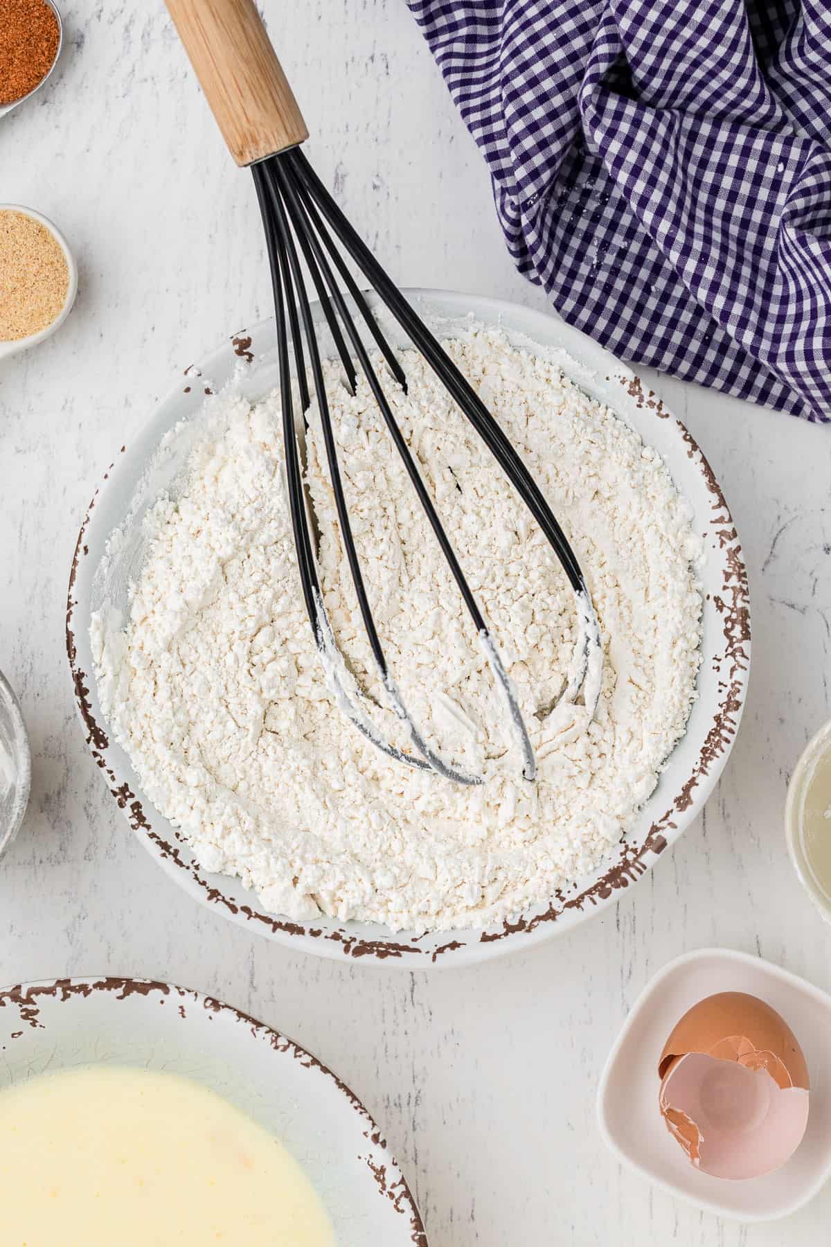 Dry ingredients to make fried pickles are combined with a wisk. 