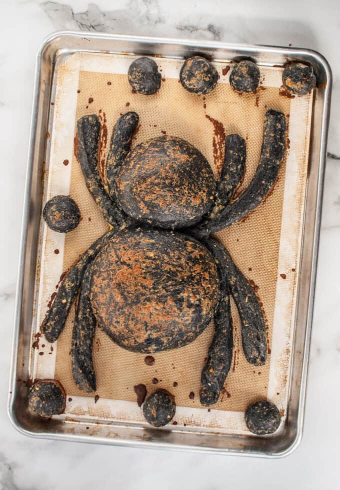 A baked spider bread bowl on a baking sheet.