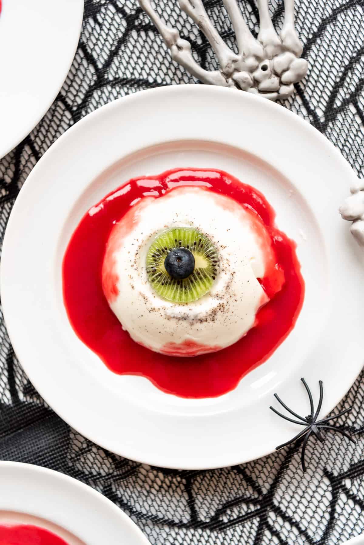 a panna cotta plated to look like an eyeball with raspberry coulis blood around it.