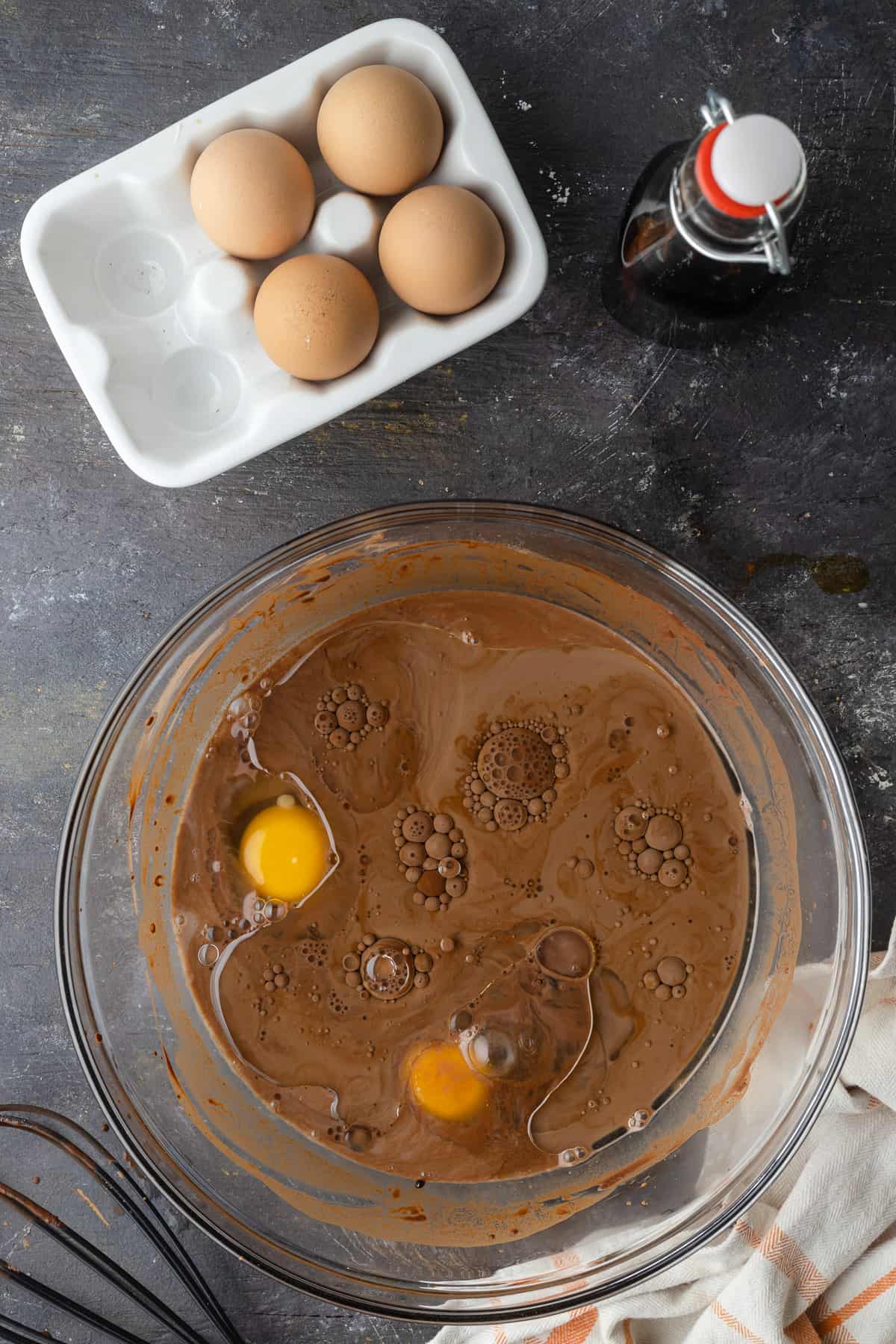 Adding oil and eggs to chocolate cupcake batter.