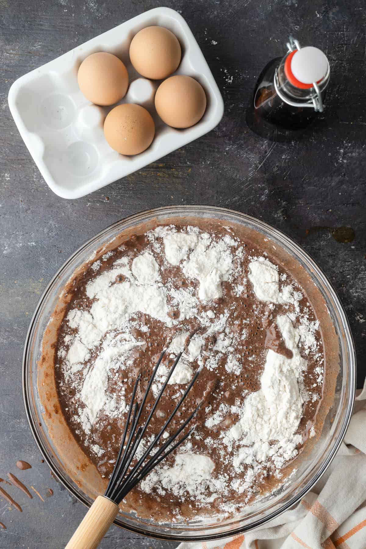 Whisking flour into chocolate cupcake batter.