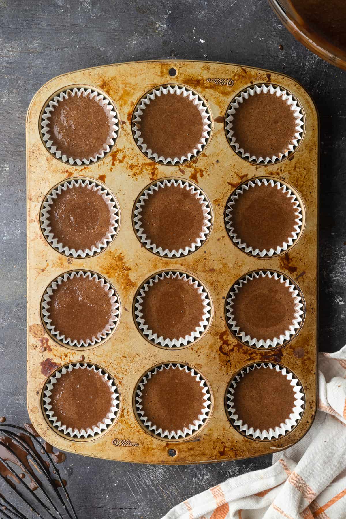 Filled cupcake liners in a cupcake pan.