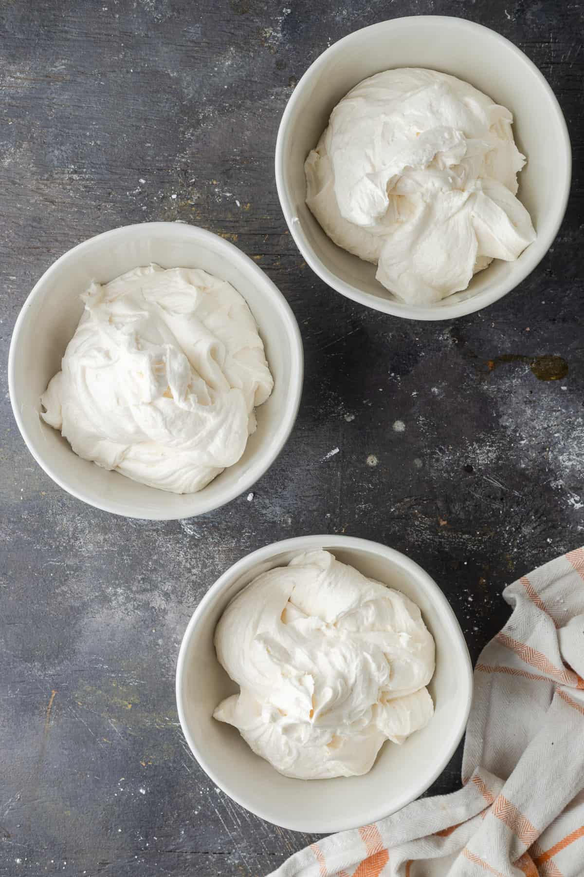 Three bowls of white frosting.