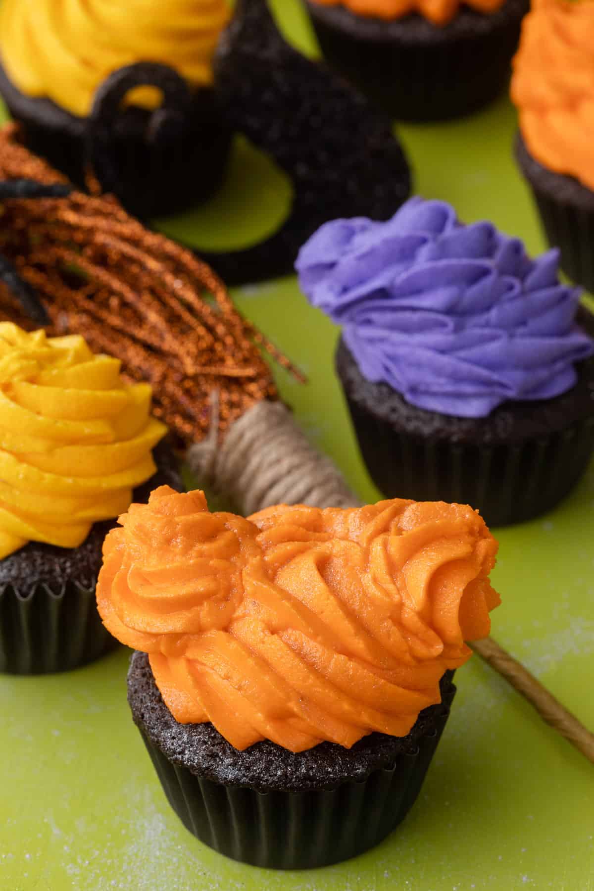 Hocus Pocus themed cupcakes with orange, yellow, and purple swirled frosting on top.