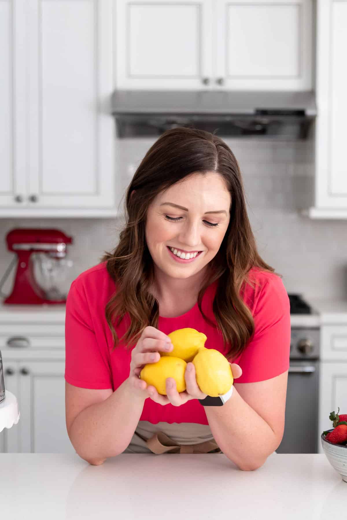 a picture of Amy Nash, the blogger behind House of Nash Eats, holding three lemons.