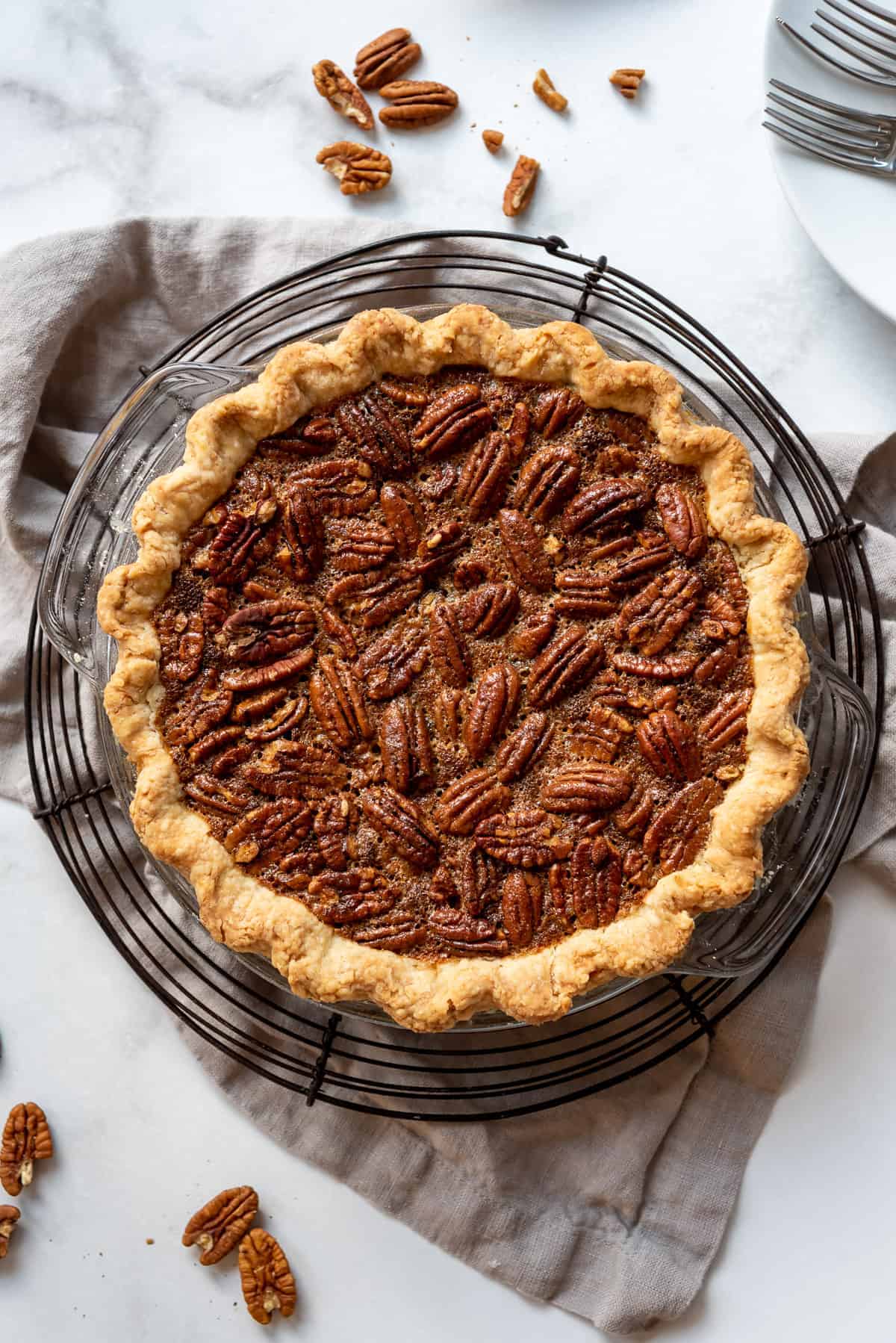 a homemade pecan pie made with whole pecans, corn syrup filling, and butter crust.