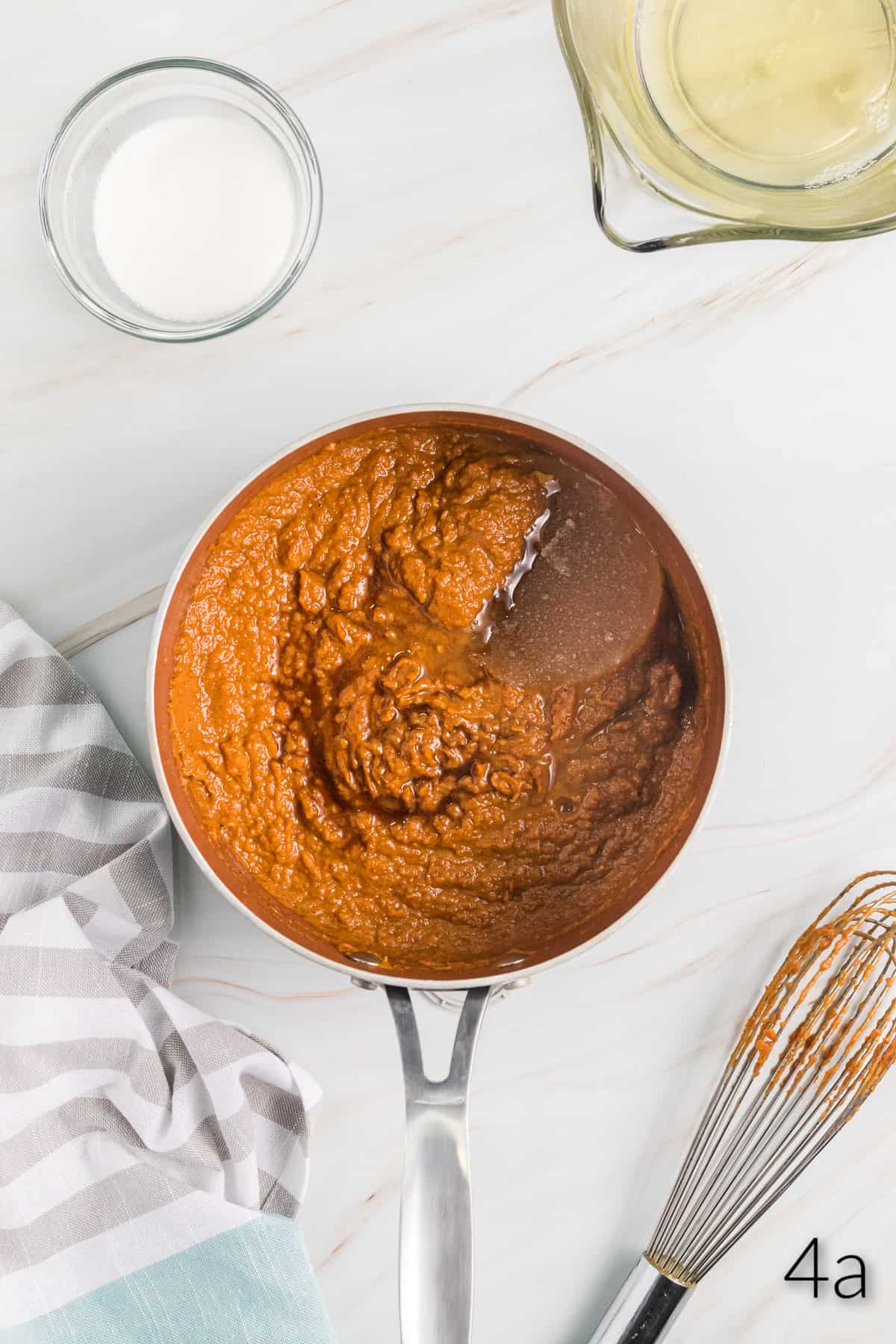 Top view of a pan with a pumpkin pie filling mix in it with water. 