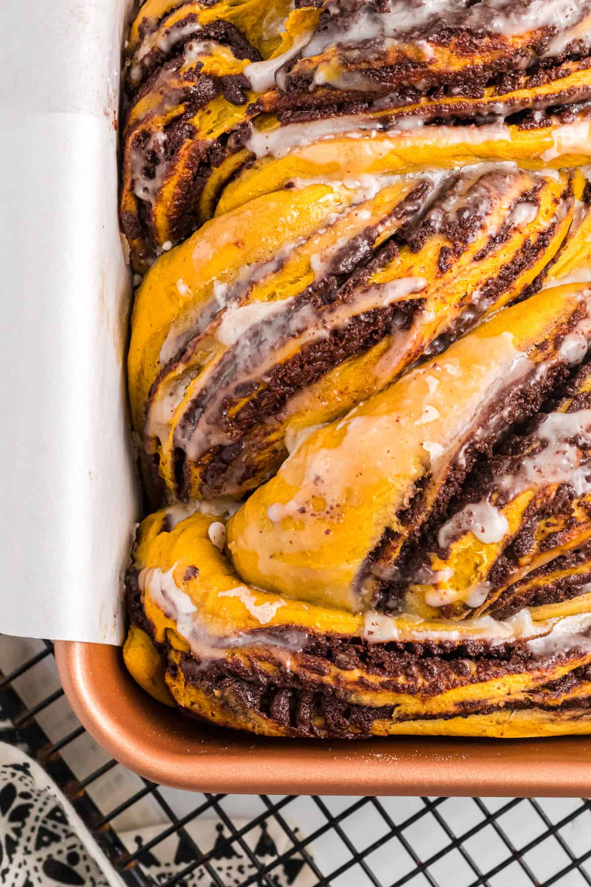 a close image of a glazed babka in a pan.