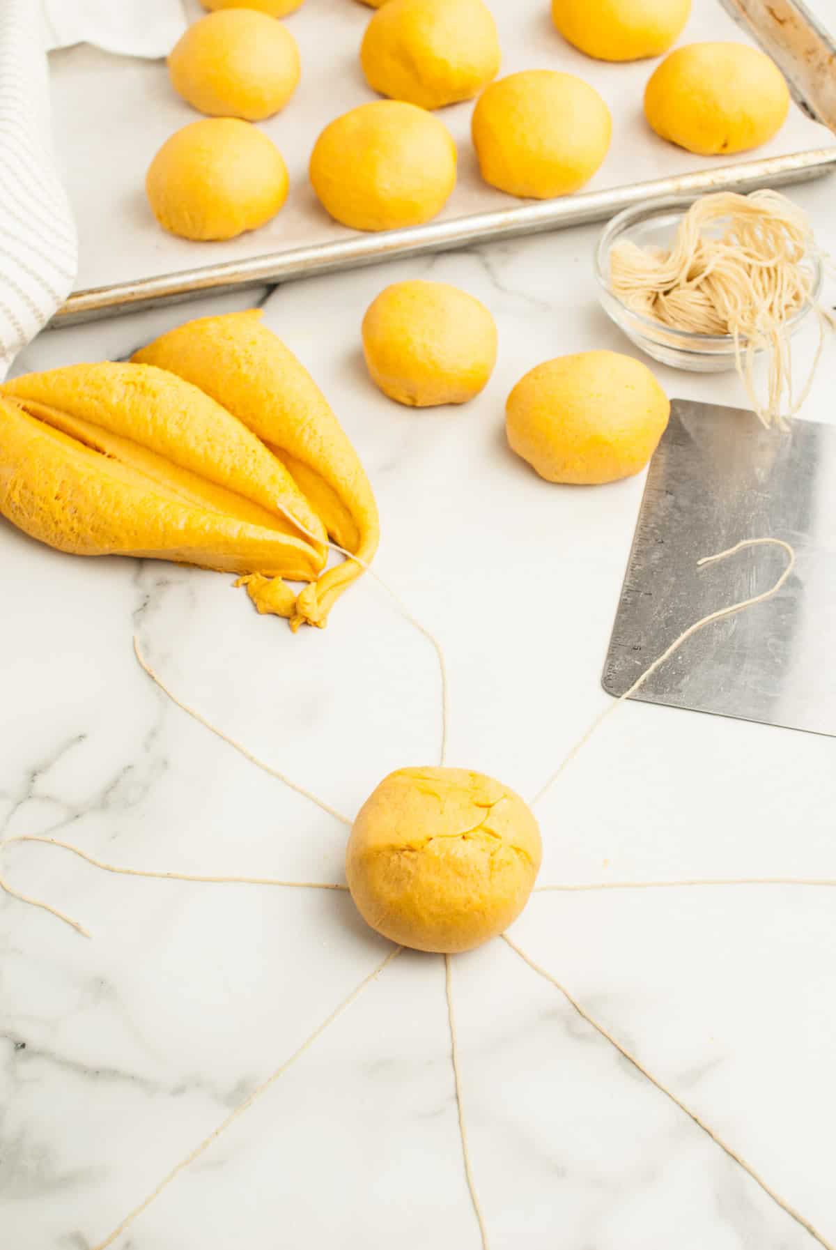 A ball of dough is placed on the center of the pie-shaped twine pattern. 