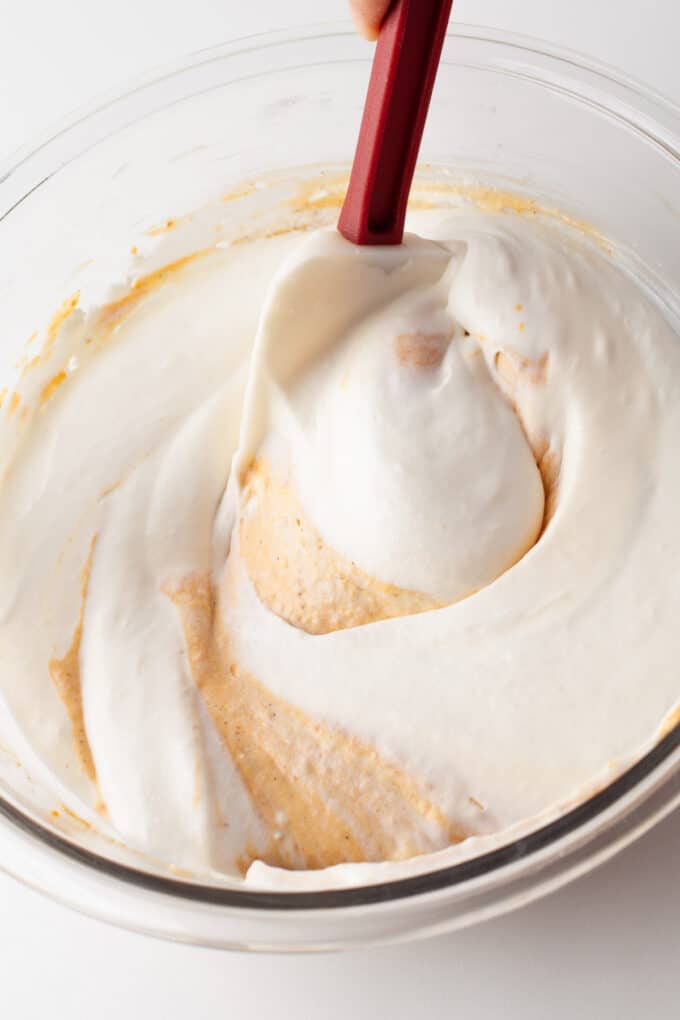 Folding whipped cream into a no-bake pumpkin cheesecake base to make mousse.