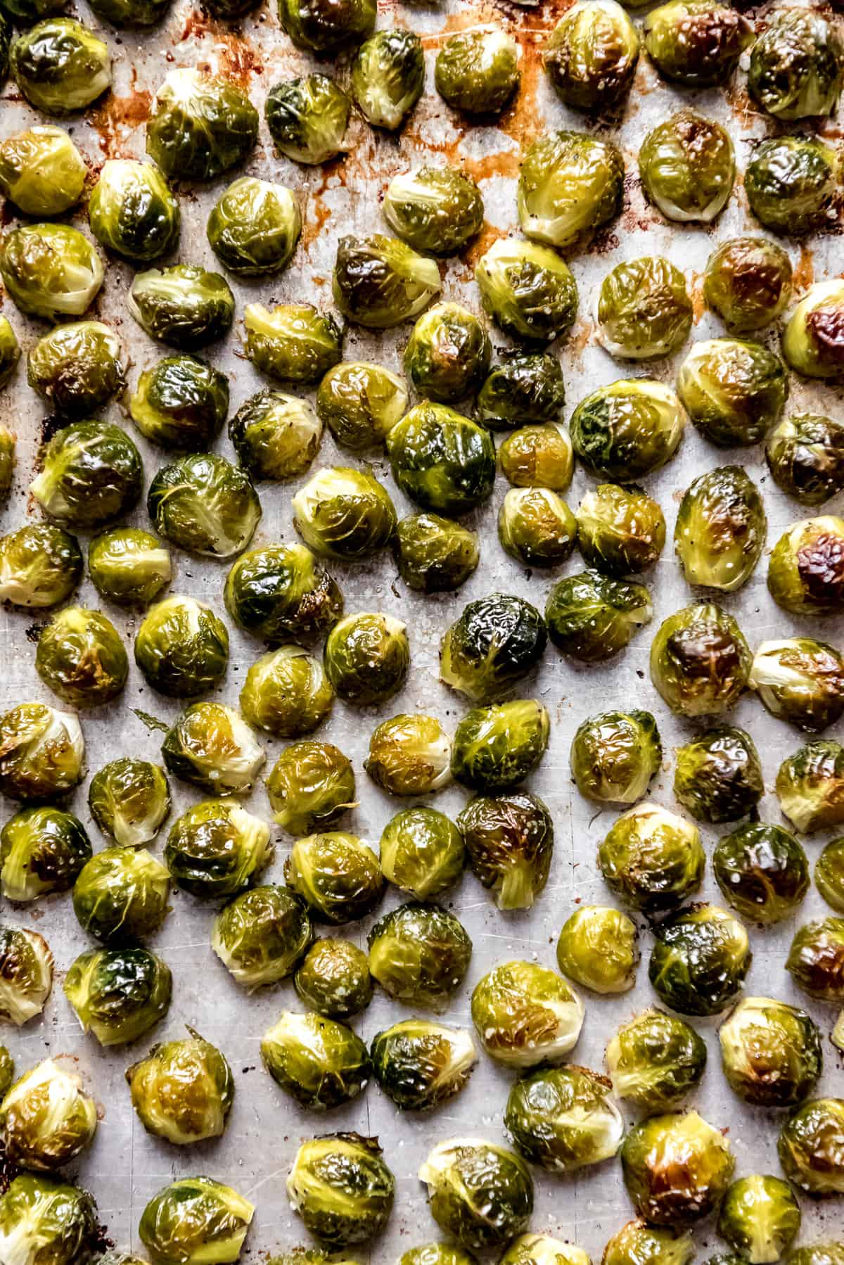 Roasted brussels sprouts on a baking sheet lined with parchment paper.