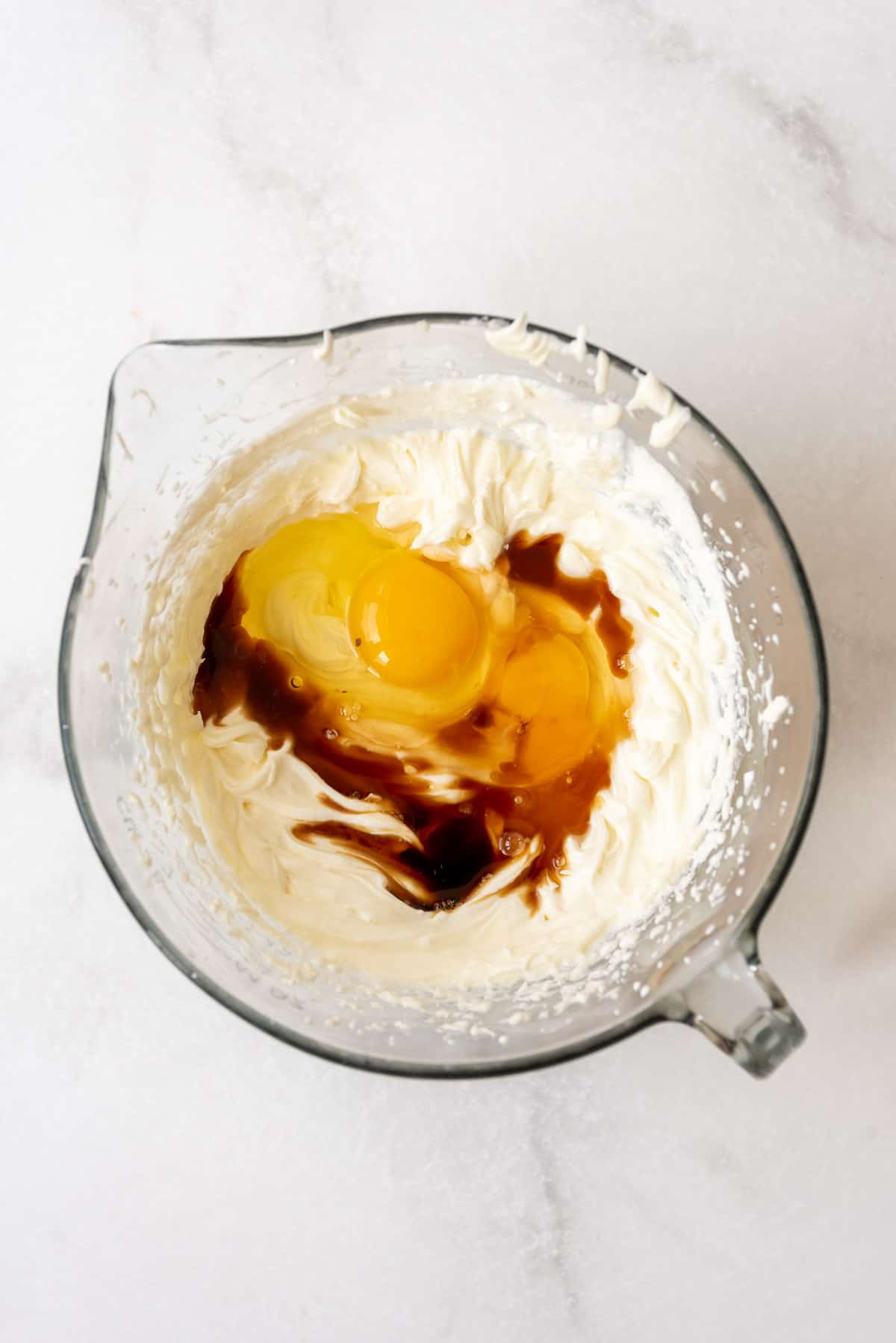 Eggs and vanilla are added to the cream cheese mixture, ready to be combined. 