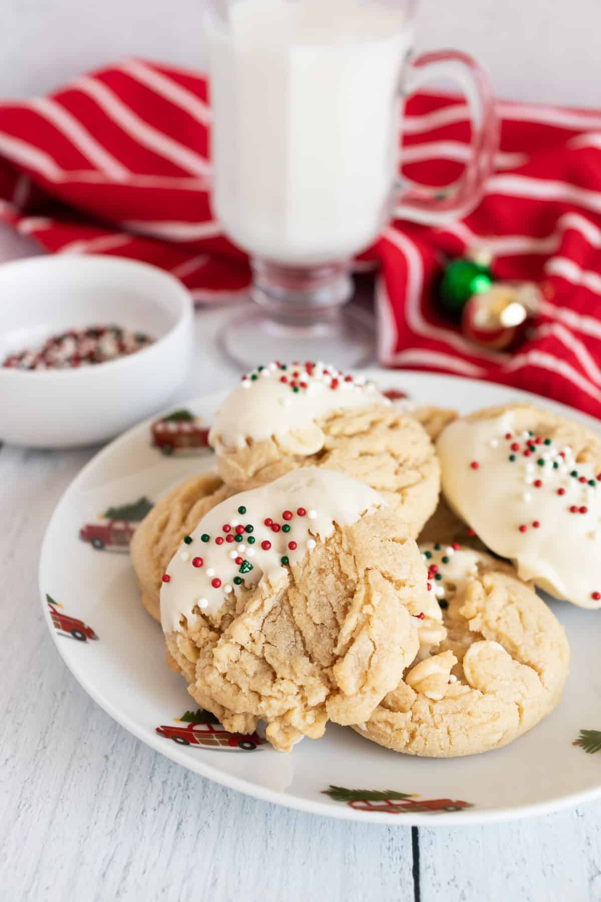 A plate of White Chocolate Peanut Butter Cookies on a white table with Christmas Decorations