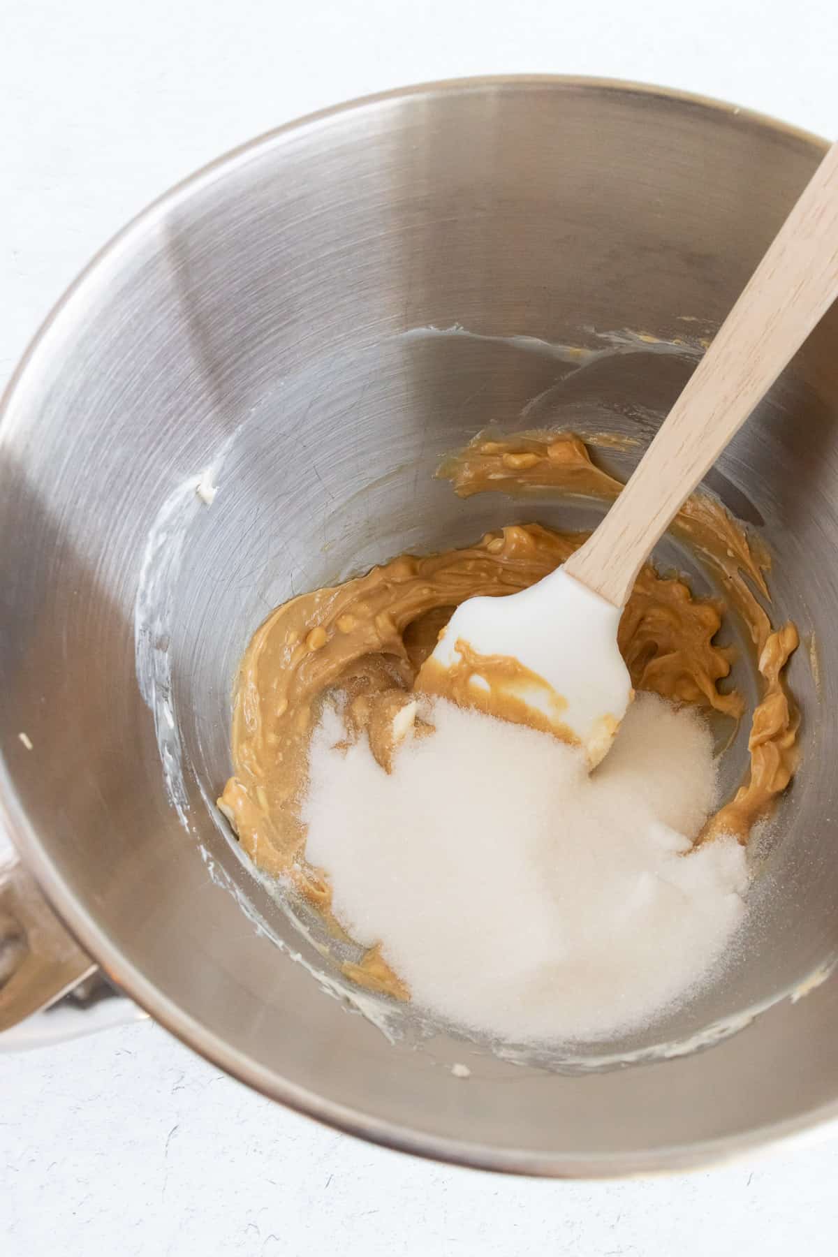 Combining peanut butter, butter and sugar. 