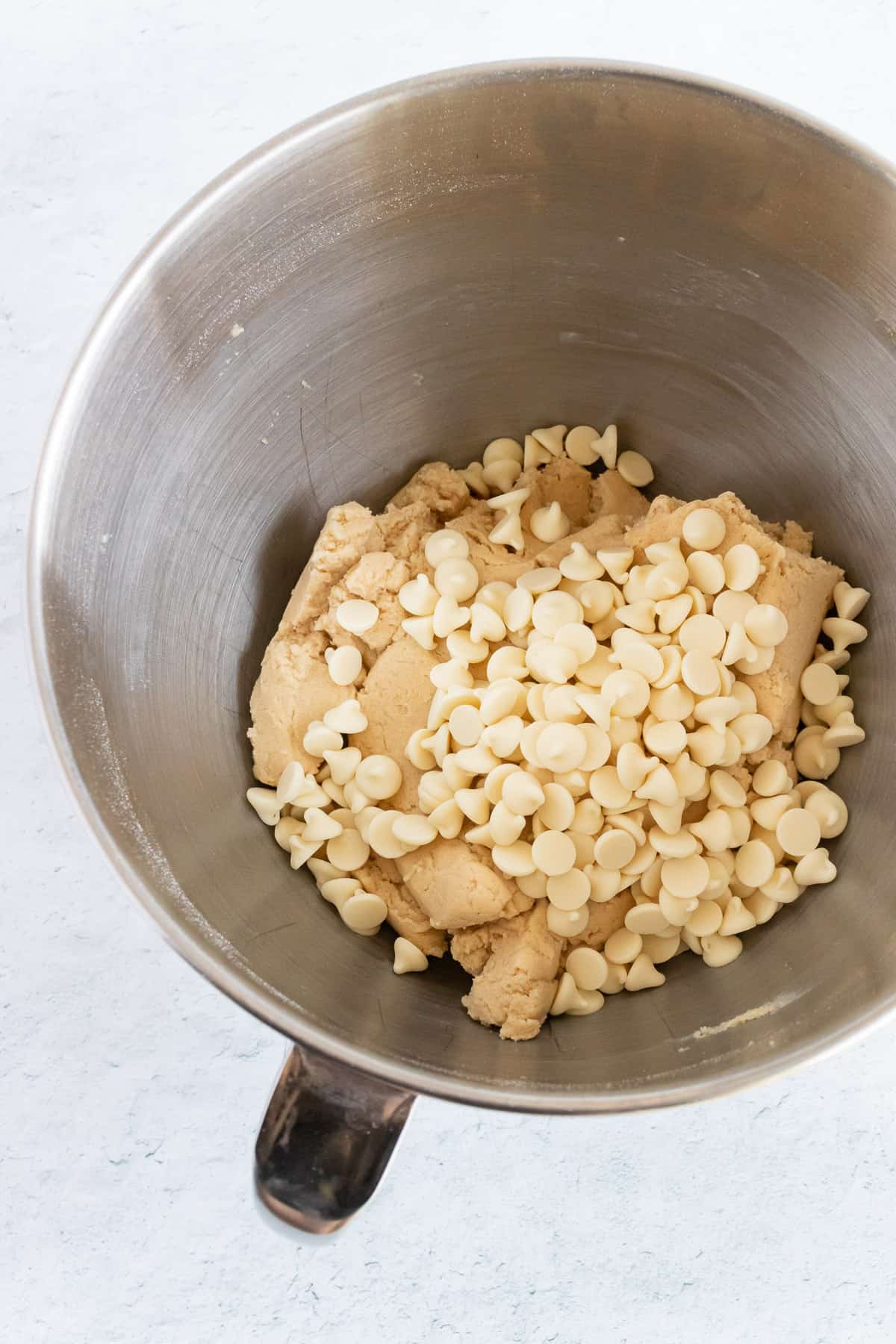 Adding white chocolate chips to the peanut butter dough. 