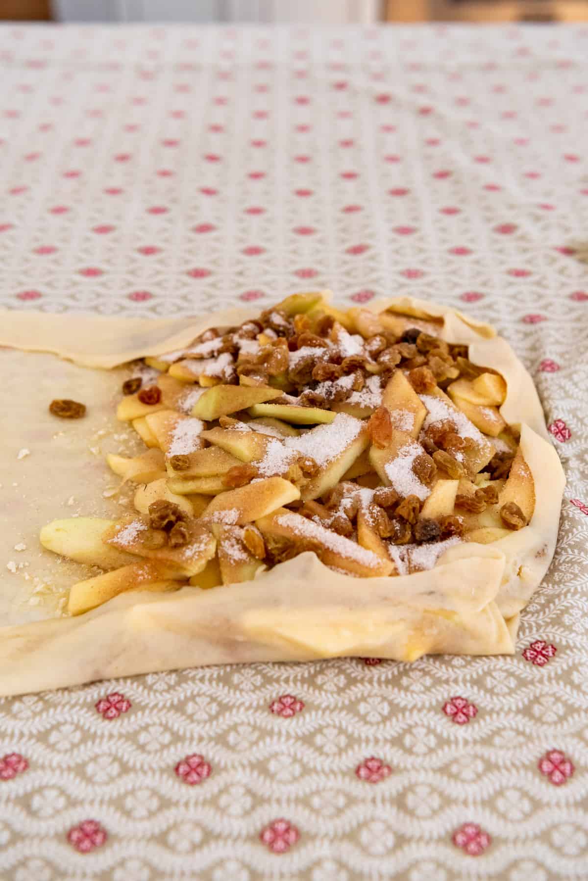 homemade strudel dough folded over an apple, cinnamon, sugar, and raisin filling.