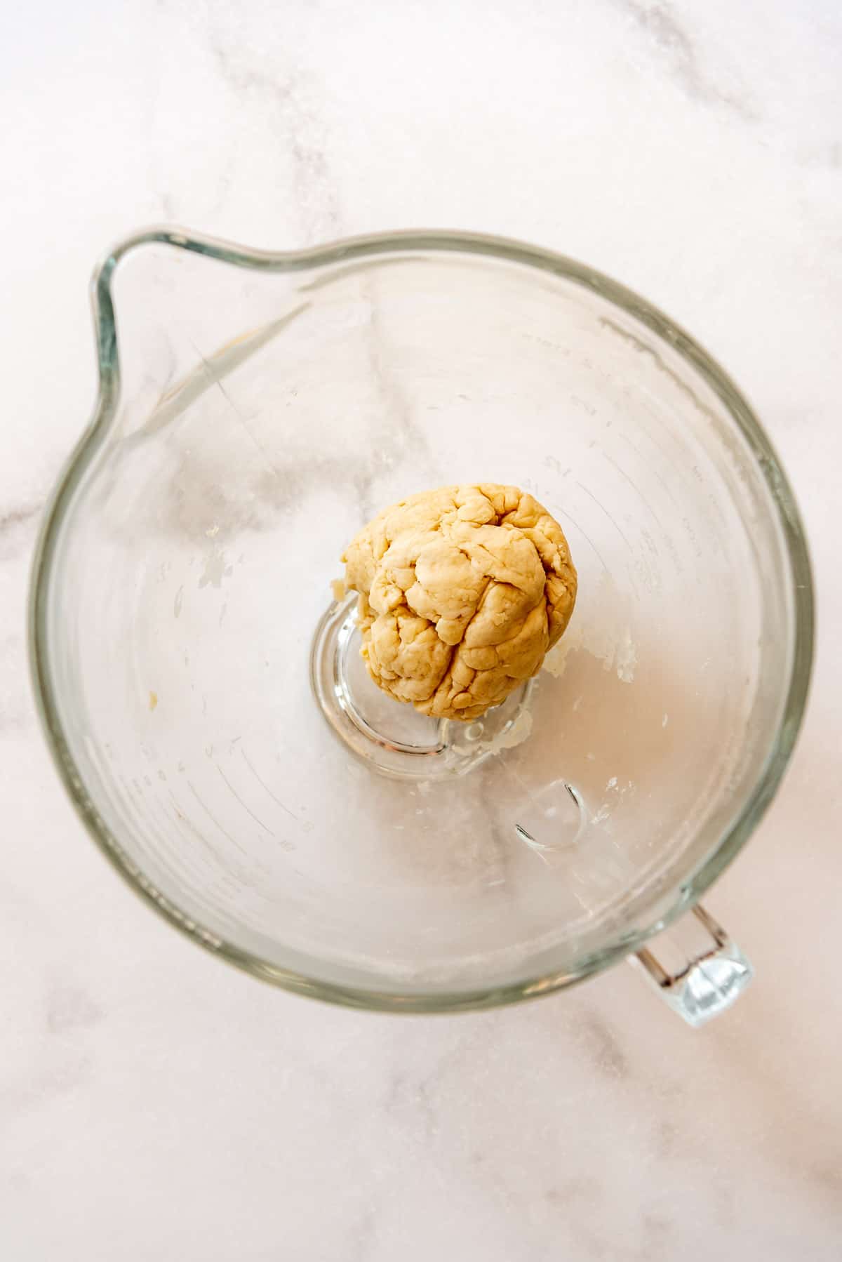 a kneaded ball of strudel dough in a glass bowl.