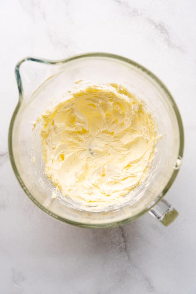 Butter that has been beaten until creamy and light in a large glass mixing bowl.