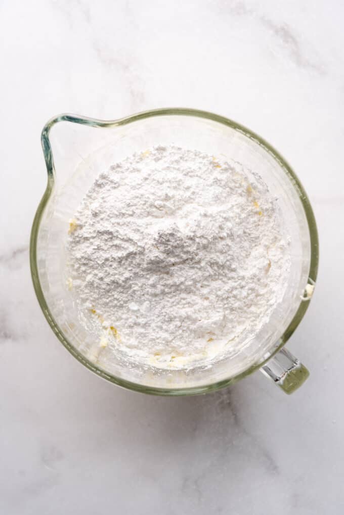 Adding powdered sugar to make buttercream frosting.