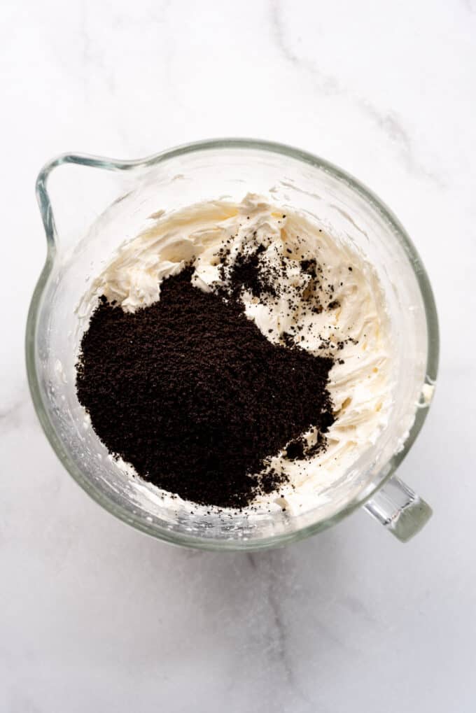 Adding finely crushed Oreos to vanilla buttercream to make cookies and cream frosting.