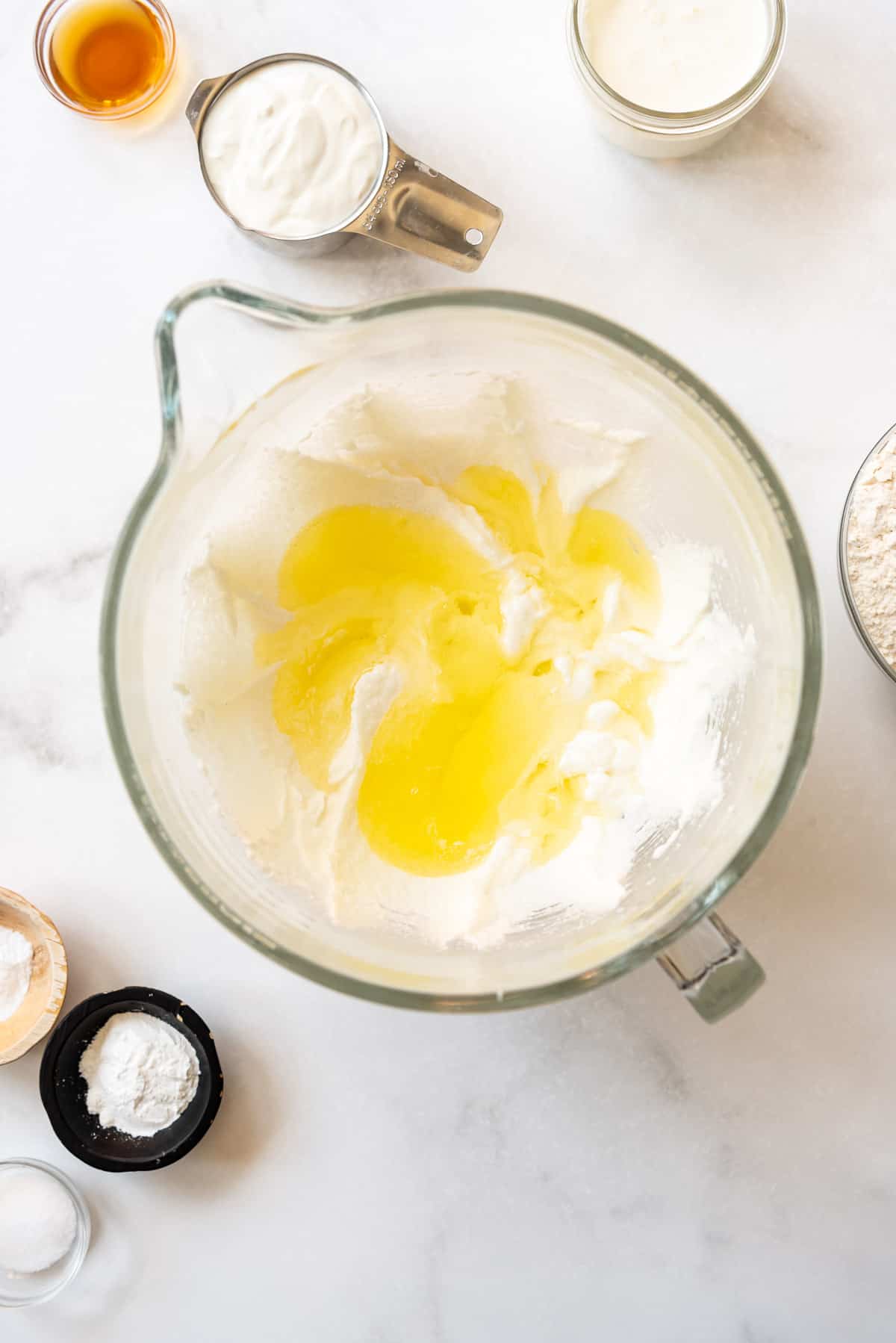 Adding egg whites to creamed oil, butter, and sugar.