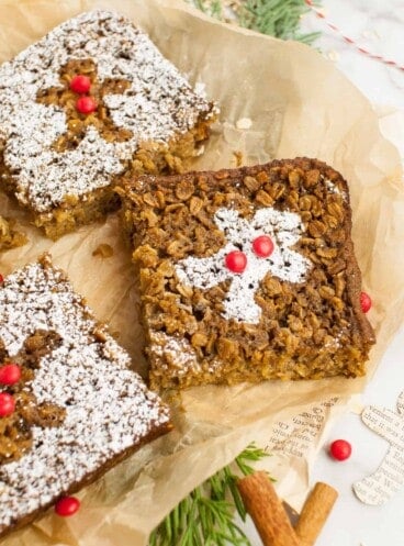 Three pieces of gingerbread baked oatmeal on brown parchment paper.