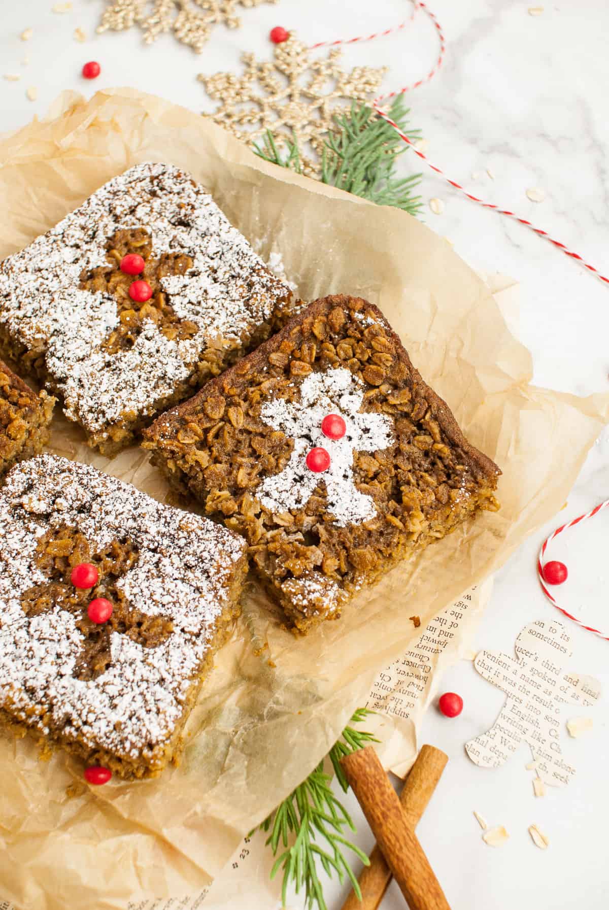 Three pieces of gingerbread baked oatmeal with gingerbread men dusted in powdered sugar on top.