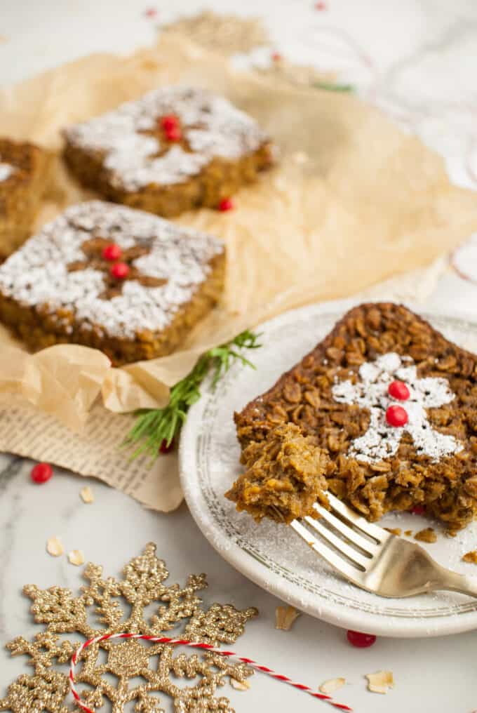 A piece of gingerbread baked oatmeal on a plate with a fork holding a bite.