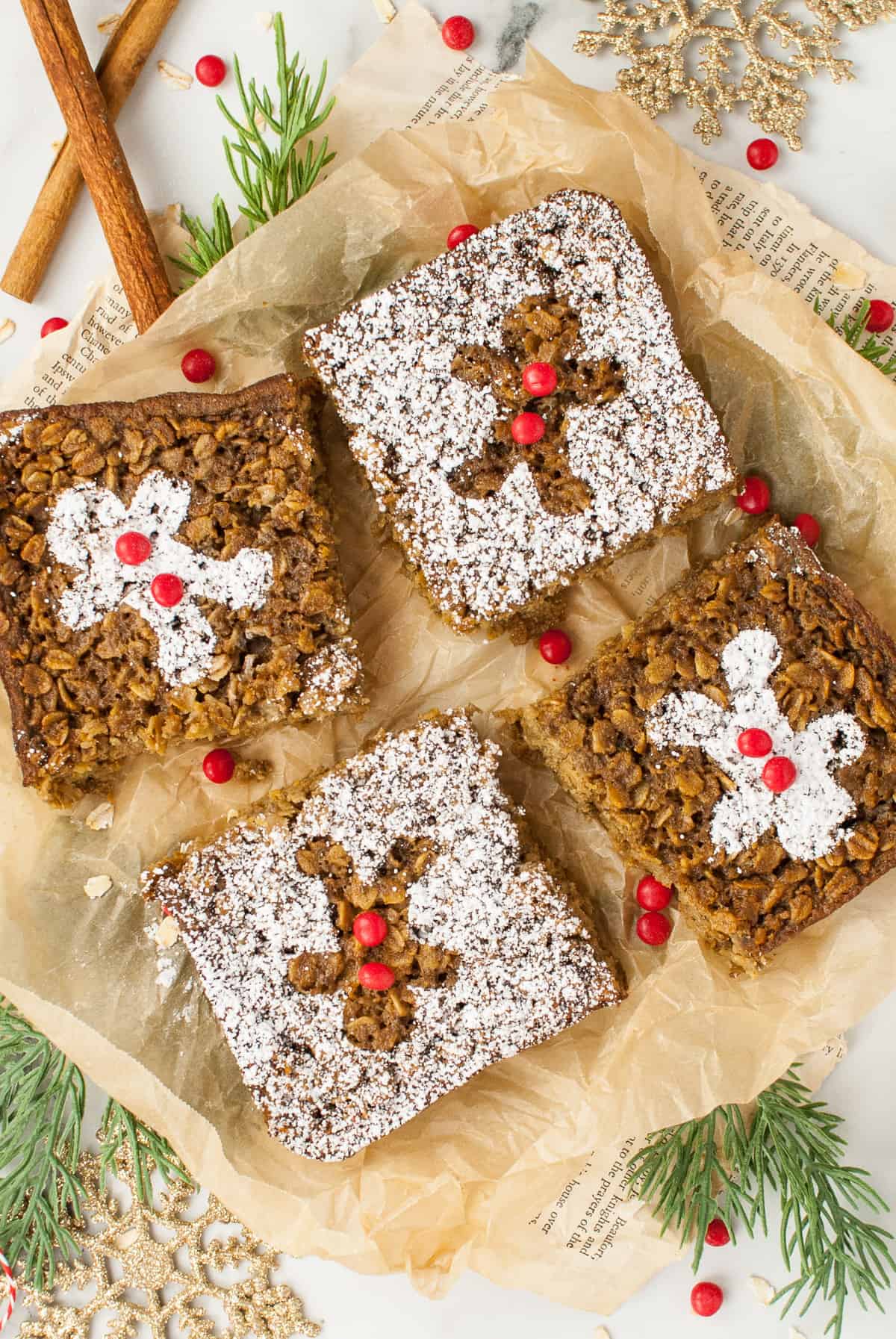 Four squares of baked oatmeal gingerbread treats are displayed, with powdered sugar decorating the tops. 