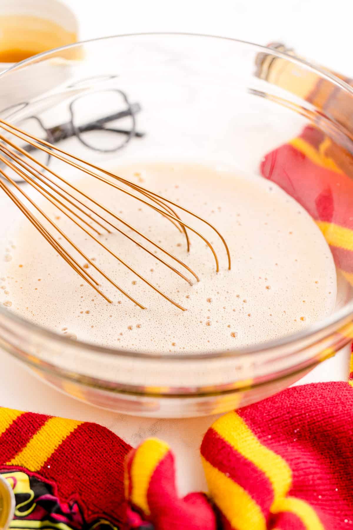 Whisking cream soda and butterscotch syrup together in a bowl.