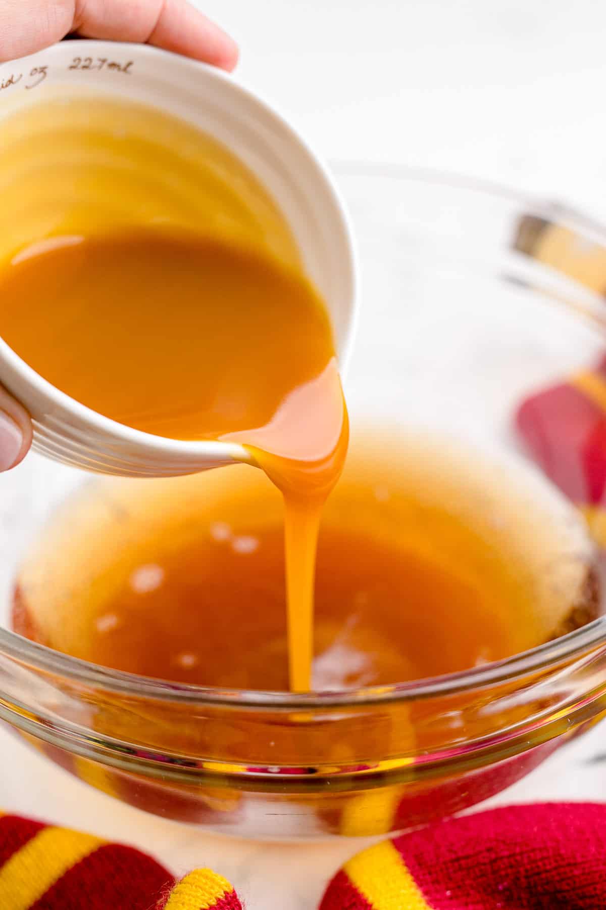 Pouring butterscotch syrup into a bowl.