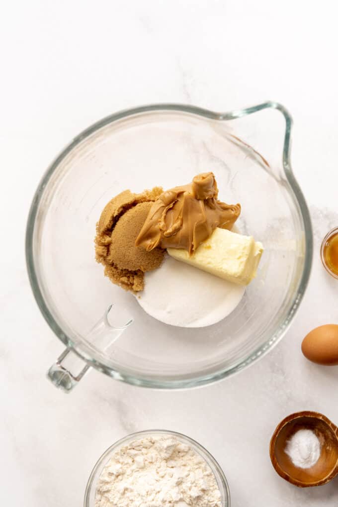 Butter, peanut butter, and sugar in a glass mixing bowl.