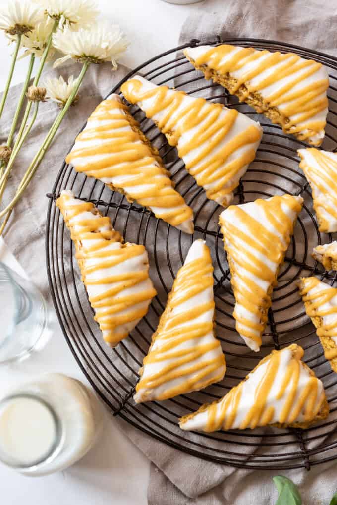 Glazed pumpkin scones on a wire cooling rack.
