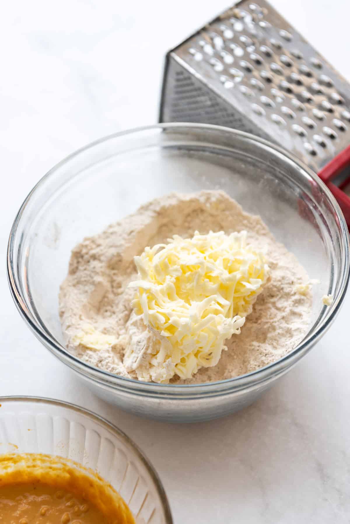 Grated cold butter in a bowl of dry ingredients for scones.
