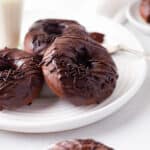 Baked chocolate donuts on a white plate.
