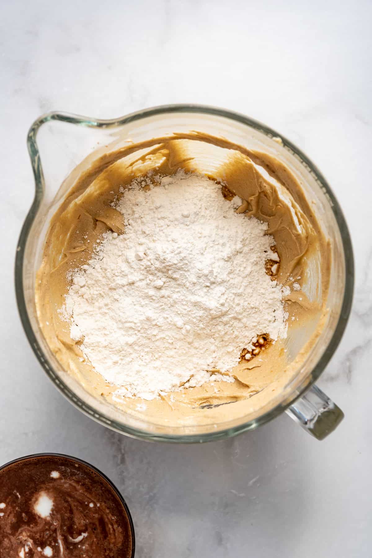 Adding dry ingredients to creamed butter and sugar.